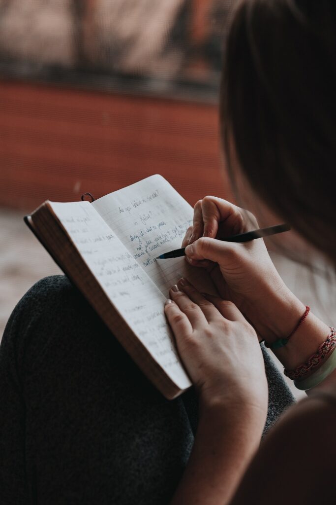 Photo of a woman writing in a journal.